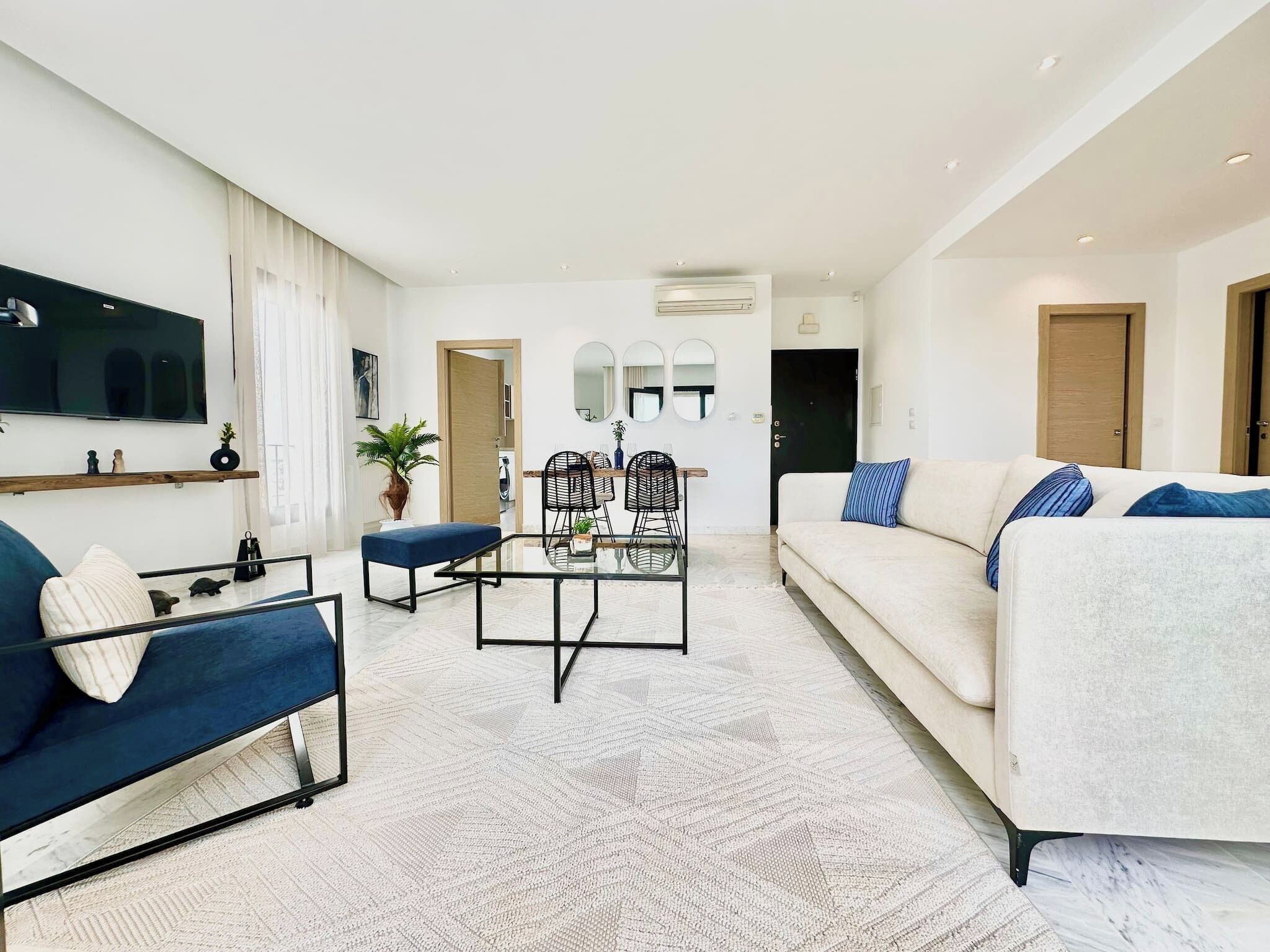 Un salon moderne avec un canapé, une table basse et un téléviseur fixé au mur.