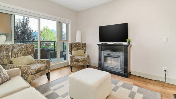 Ein Wohnzimmer mit Kamin, Fernseher und einer Couch.
