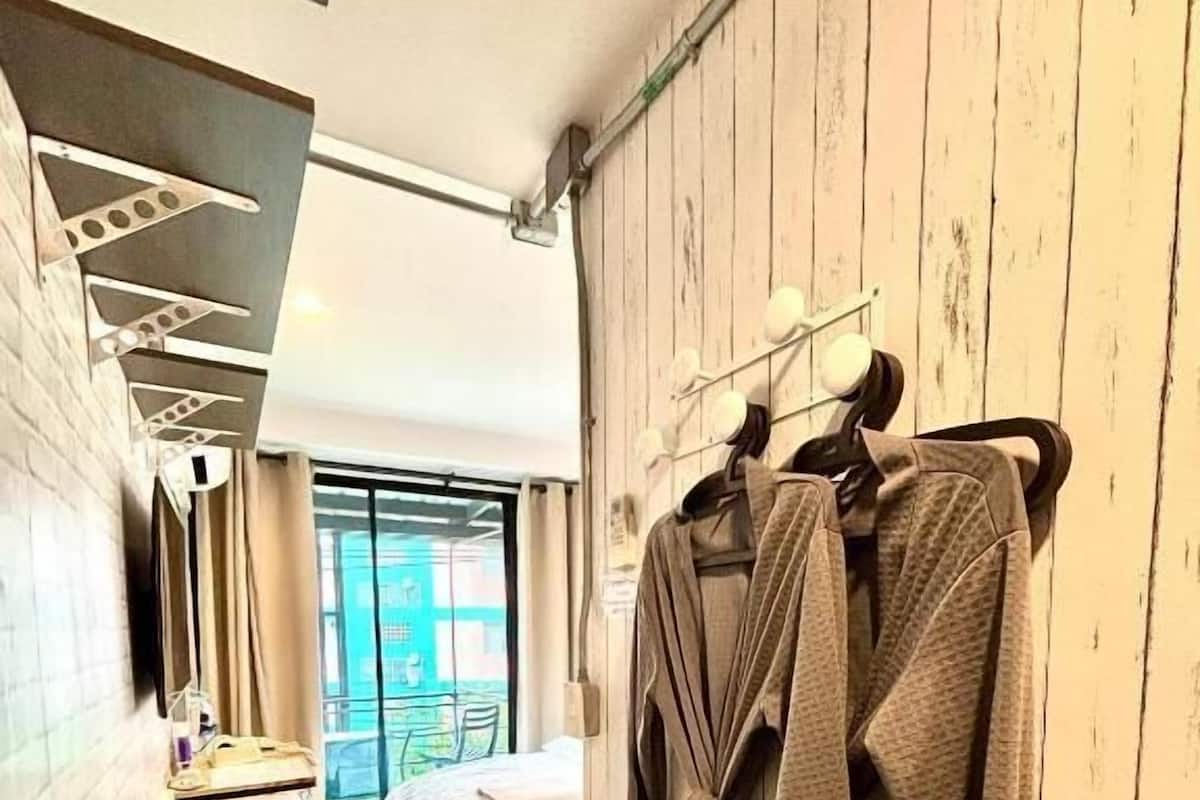 A hotel room with a bed, a desk, a wardrobe, and a window with a view.