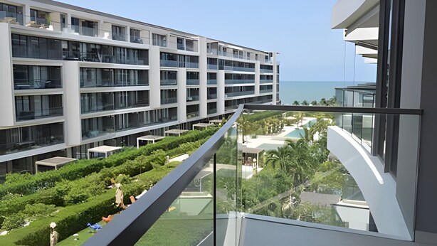 Ein modernes Hotel mit mehreren Etagen, einer Glasufernung und Meerblick.