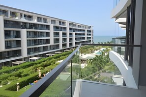 Ein modernes Hotel mit mehreren Etagen, einer Glasufernung und Meerblick.