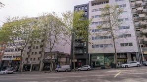 Ein mehrstöckiges Gebäude im modernen Architekturstil, das sowohl Geschäfts- als auch Wohnräume vereint.