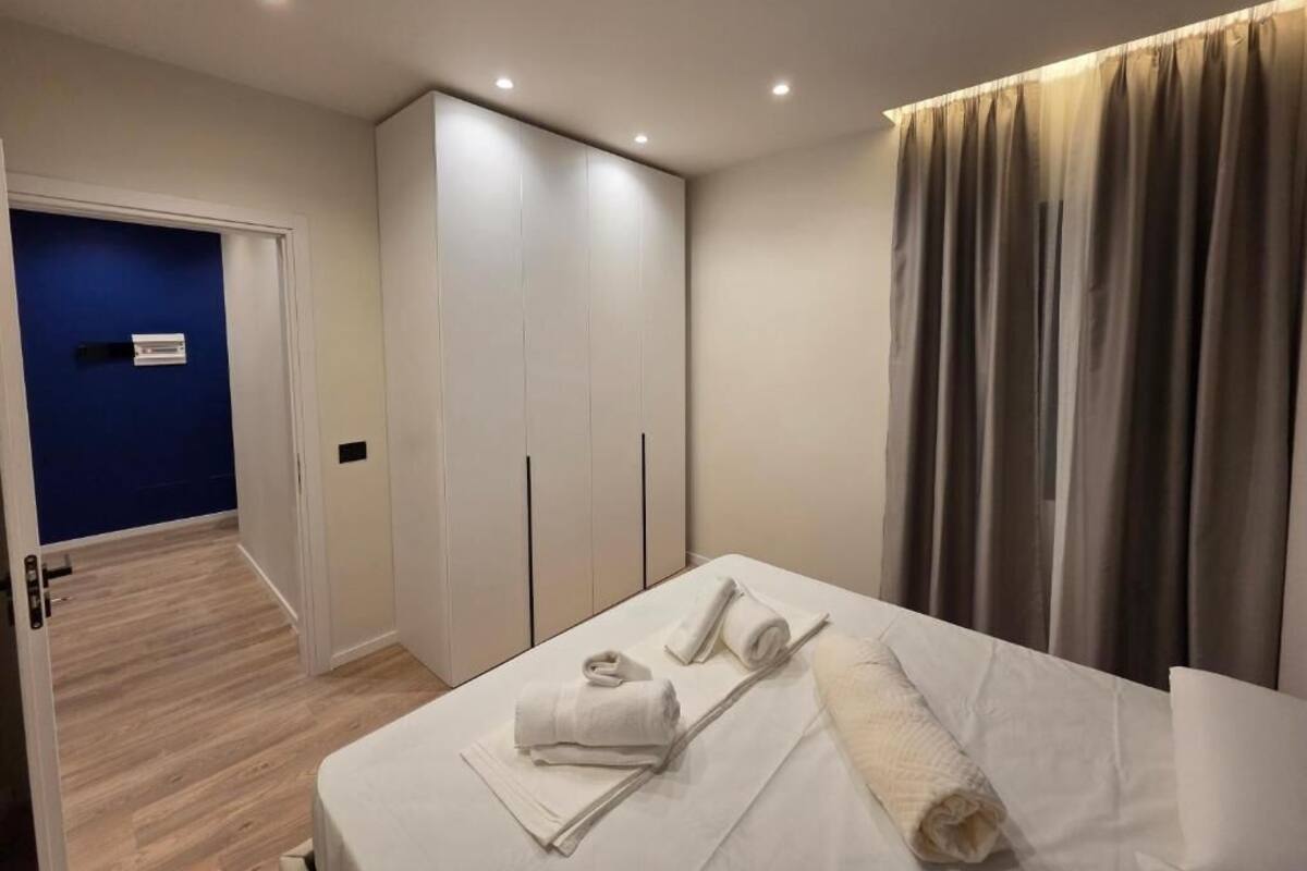 Una habitación de hotel con cama, armario, baño y vistas al exterior.