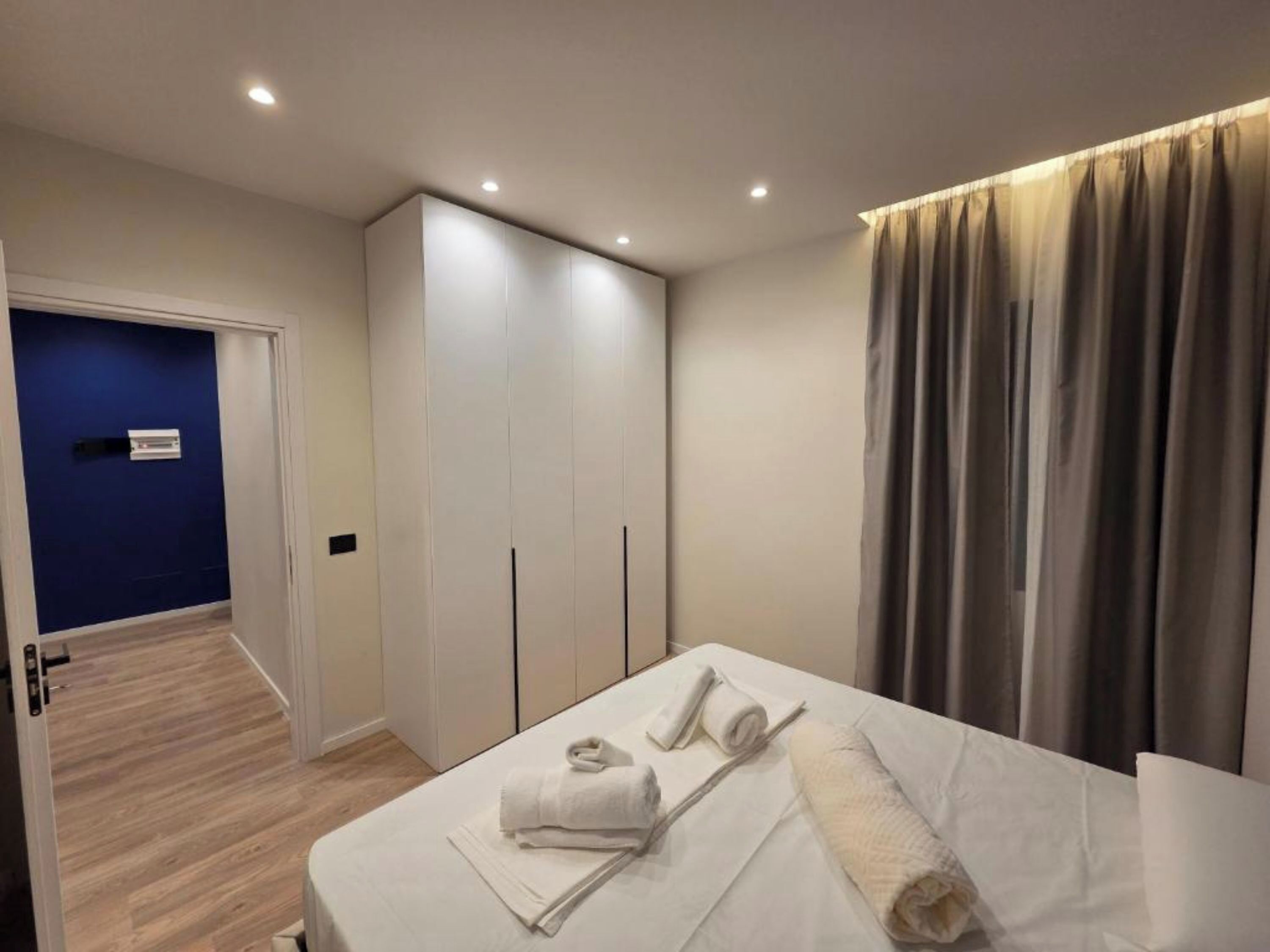 Une chambre à coucher comprenant un lit, une armoire, une salle de bain et un couloir.