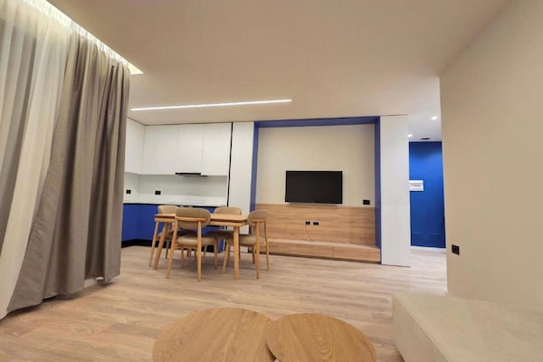 Apartamento Deluxe | Zona de estar | Televisión de pantalla plana de 42 cm con canales por satélite