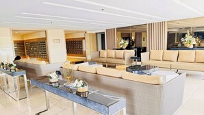 Un salon moderne avec un canapé d’angle, une table basse en verre et un espace détente équipé d’un téléviseur.
