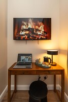 A wooden desk with a laptop, a lamp, and a tray with snacks.