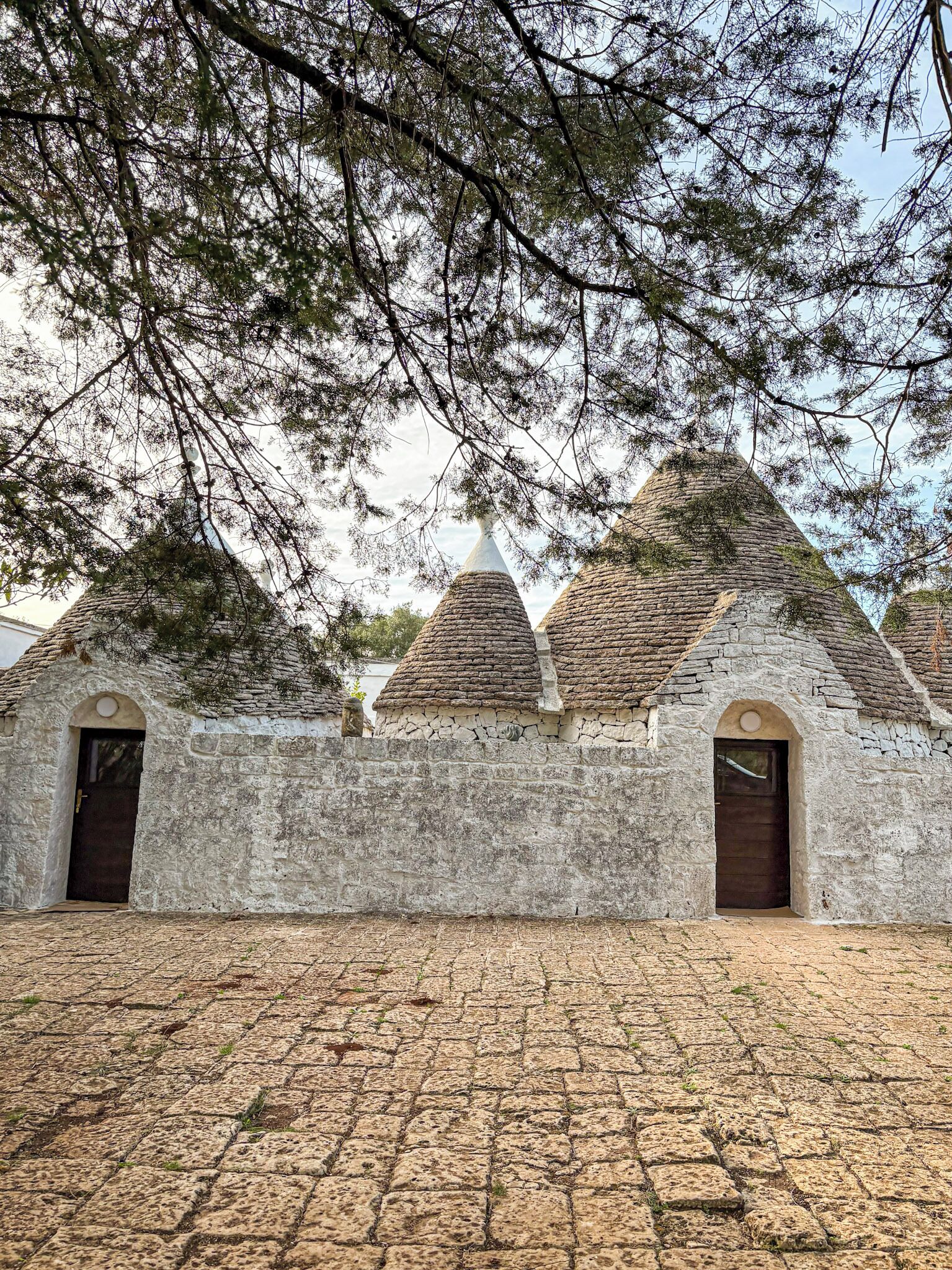 A stone building with conical roofs and arched doorways.