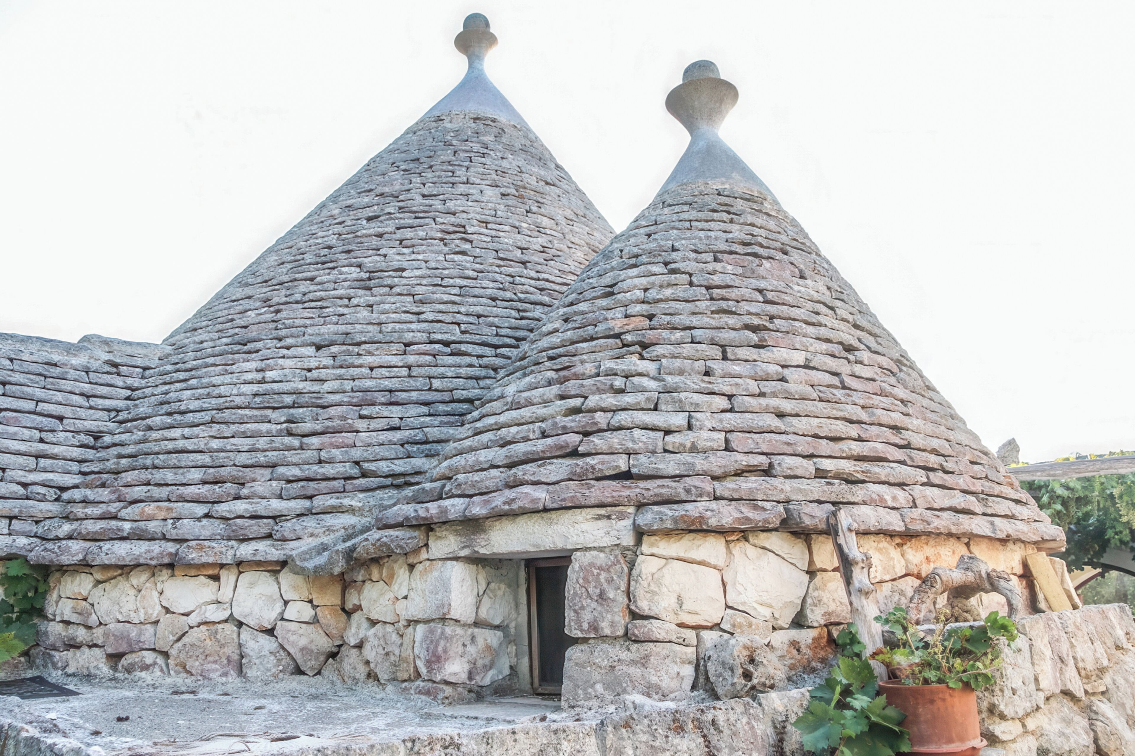 A stone building with conical roofs and a small entrance.