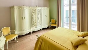 Ein Schlafzimmer mit Bett, Kleiderschrank, Stuhl und Fenster.