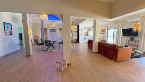 An open-plan living area with a dining set, sofas, and a TV. - Palais Mahdi (Marrakech)
