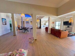 An open-plan living area with a dining set, sofas, and a TV. - Palais Mahdi (Marrakech)