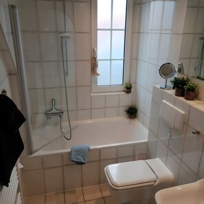 Une salle de bain équipée d’une baignoire, de toilettes et d’un espace douche.