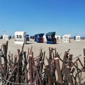 Cabanes de plage numérotées 35, 36, 38 et 19, avec un ciel dégagé et la mer en arrière-plan.