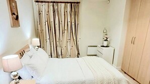 A bedroom with a bed, bedside tables, a wardrobe, a desk, and a lamp. - Room-charming Double Bedroom With Stunni (Wexford)