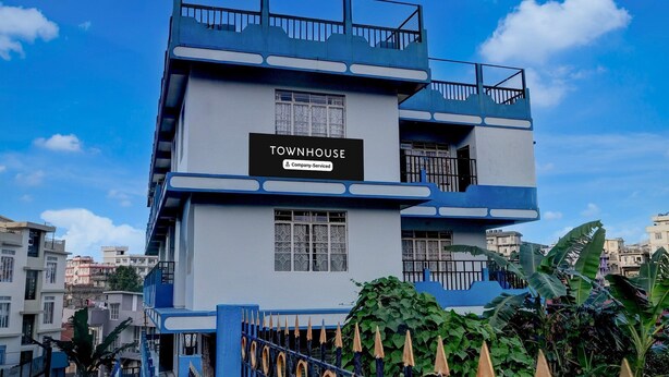 A multi-story building with a sign reading 'TOWNHOUSE Company-Serviced.' - Super Townhouse Howell Crossway Shillong (Shillong)