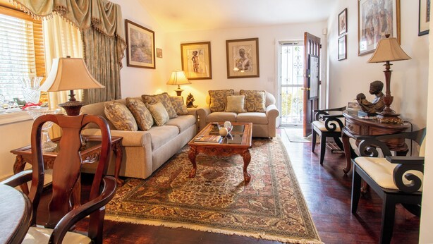 Un salon comprenant un canapé, des fauteuils, une table basse et un tapis.