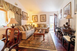 Een woonkamer met een bank, fauteuils, een salontafel en een vloerkleed.