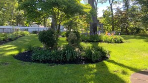Un jardin bien entretenu, agrémenté de diverses plantes et d’un belvédère.