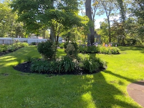 A well-maintained garden with various plants and a gazebo. - Peaceful 3BR Garden Cottage Long Island Escape (Coram)