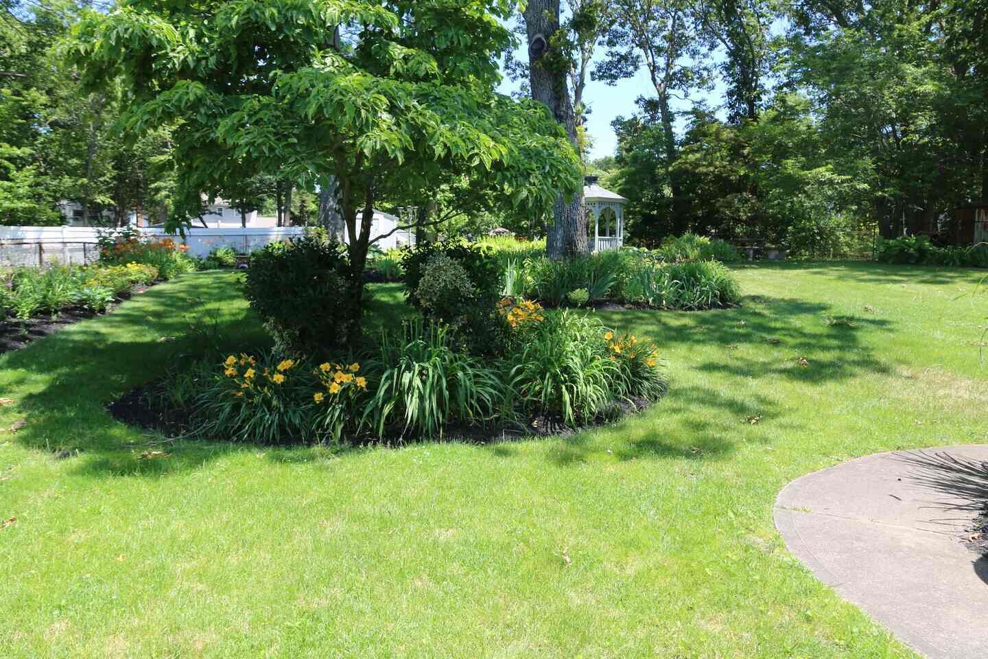 A well-maintained garden with a variety of plants and a gazebo.