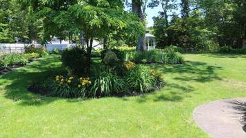 A well-maintained garden with a variety of plants and a gazebo.