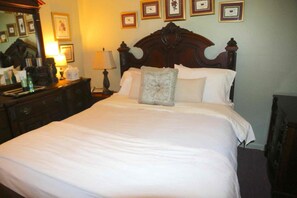 Un lit bien fait, agrémenté d’un seul coussin décoratif, dans une chambre d’hôtel.