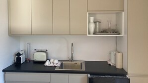 A kitchen with a black countertop, a sink, a toaster, and a cabinet above the counter. - Wonderfully private vacation home near the lake on Lake Chiemsee with large garden & terrace (Gstadt am Chiemsee)
