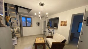 Un salon comprenant un canapé, une table basse, un lustre, un escalier et une vue sur l’extérieur.
