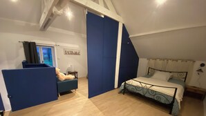 Une chambre à coucher avec un lit, une chaise, une fenêtre et une porte.