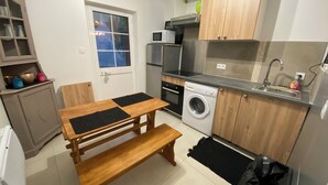 Une cuisine compacte équipée d’un lave-linge, d’un four à micro-ondes et d’un évier.