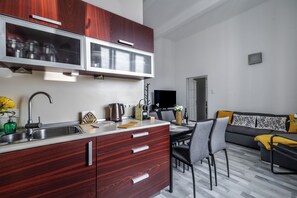 Eine moderne Küche mit integriertem Mikrowellenherd, Spüle und Essbereich mit Tisch und Stühlen.