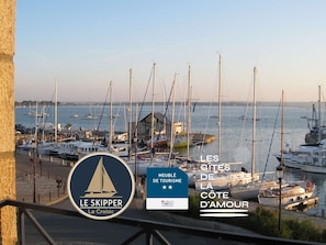 A marina with boats docked, a sign for 'Le Skipper Le Croisic,' and a tourism sign for 'Les Sites de la Côte d'Amour.' - Le skipper - Les Gîtes de la Côte d'Amour (LE CROISIC)