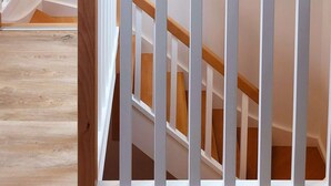 A staircase with wooden railings and a white wall. - Le clos du prieuré - Les Gîtes de la Côte d'Amour (BATZ SUR MER)
