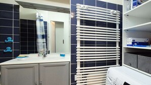 Ett utrymme för tvätt med tvättmaskin, torkställning och handfat.