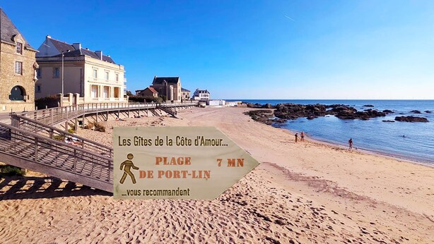 Una playa con un letrero que recomienda Les Gîtes de la Côte d'Amour, a 7 minutos a pie de Port-Lin.
