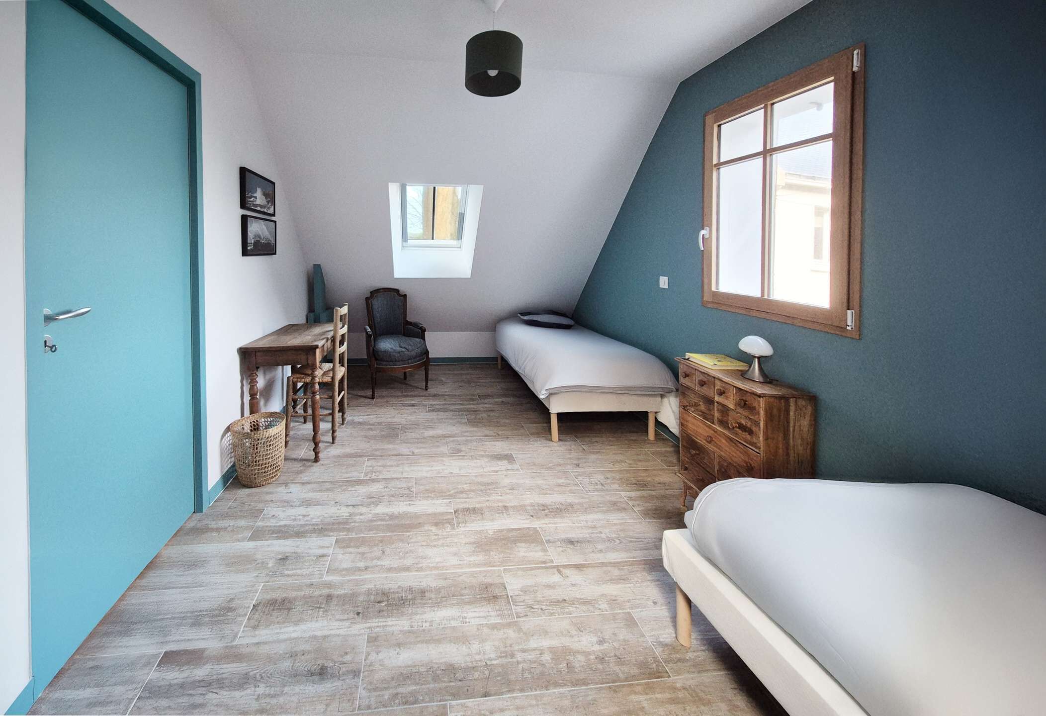 Ein Zimmer mit einem Bett, einem Schreibtisch, einem Stuhl, einem Fenster und einer Tür.