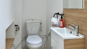 A small, white bathroom with a toilet, a sink, and a mirror. - Maison Azur à la Marsa Plage (La Marsa)