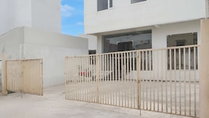 Μια περίφραχτη είσοδος σε ένα κτίριο με έναν τοίχο από σκυρόδεμα και μια μεταλλική πύλη.