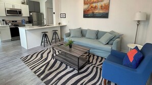 A modern living room with a sofa, a coffee table, and a zebra-patterned rug. - Trendy Bungalow near Armature and Downtown Tampa (Tampa)