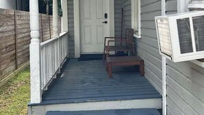 A house with a porch, a door, and a small table. - Trendy Bungalow near Armature and Downtown Tampa (Tampa)
