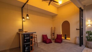 Ein modernes Interieur mit Küchenzeile, Sitzgelegenheiten und einer Treppe zu einer oberen Ebene.