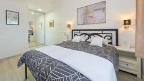 A bedroom with a bed, bedside tables, a mirror, and a wall with a framed picture. - Villa Argenta in lovely Aržano, Croatia (Aržano)