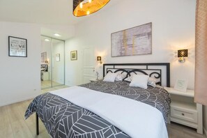 A bedroom with a bed, bedside tables, a mirror, and a wall with a framed picture. - Villa Argenta in lovely Aržano, Croatia (Aržano)