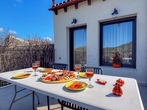 Un espace de restauration en plein air avec une table dressée pour deux personnes, proposant une variété de plats et de boissons.