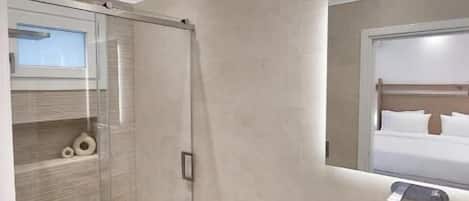 Suite Deluxe, vue sur la mer | Salle de bain | Douche, articles de toilette (gratuits), pantoufles, serviettes fournies