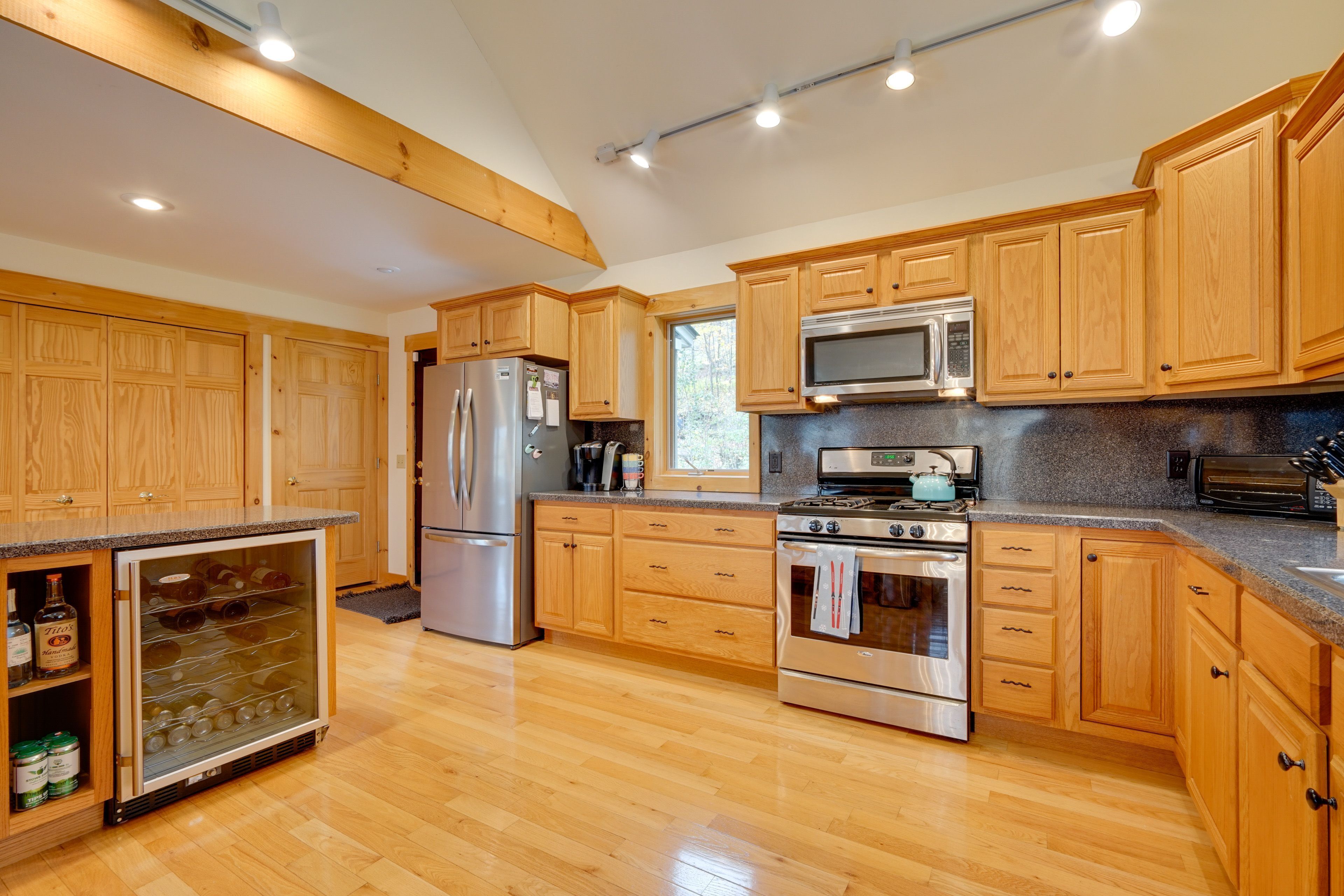 A kitchen with wooden cabinets, stainless steel appliances, and a built-in wine cooler.