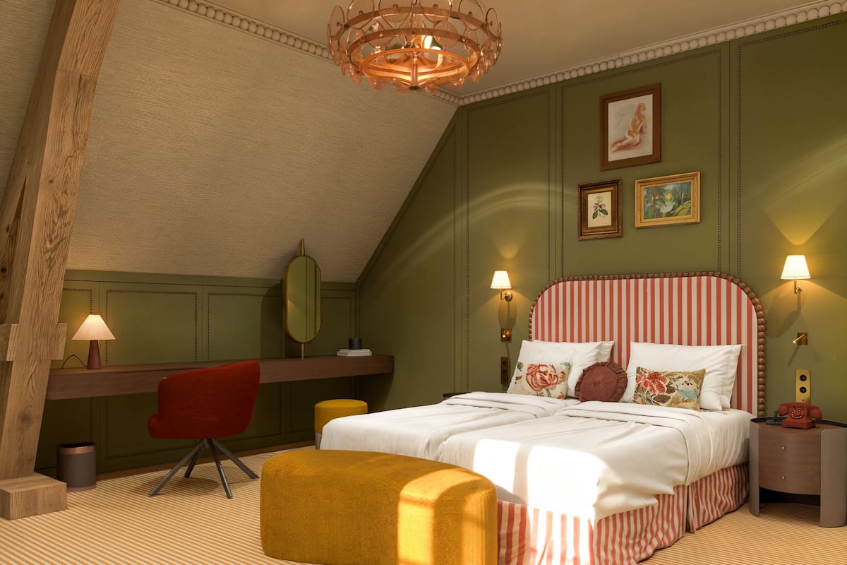 A bedroom with a bed, a desk, a chair, a lamp, and a telephone.