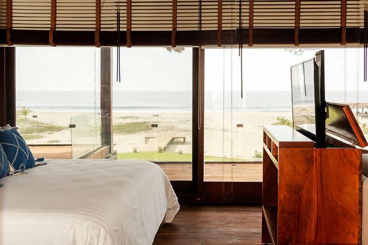 Ein Schlafzimmer mit einem Bett, einer Holzkommode und einem Fernseher.