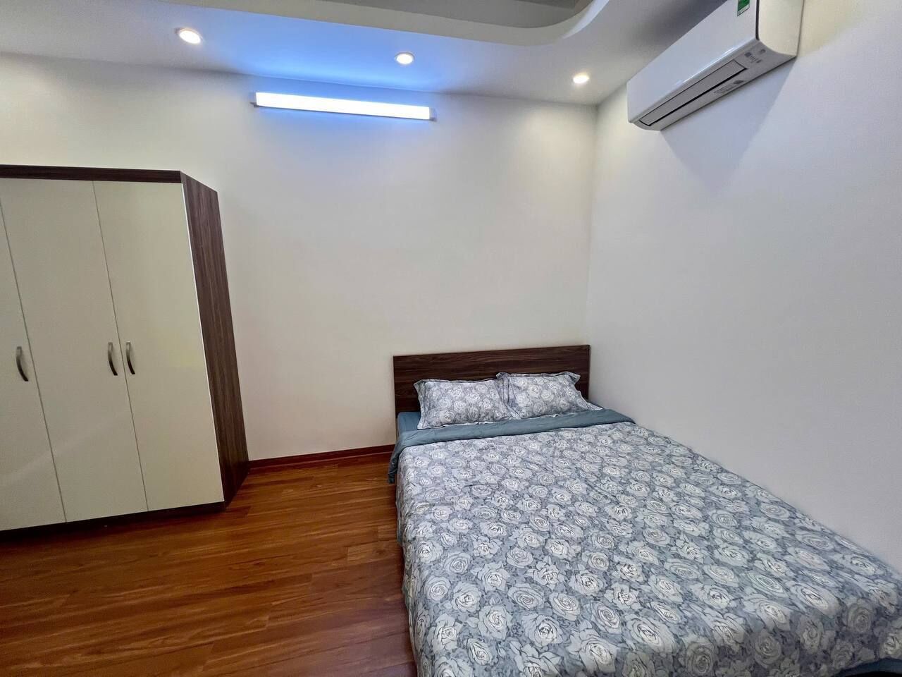 Ein Schlafzimmer mit Bett, Kleiderschrank und Klimaanlage.